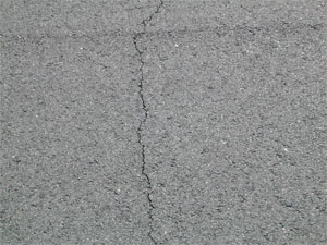 Close-up photo of a single low-severity crack. The crack is tight and has no visible spalling.